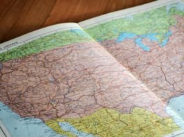 map of the world book laid open on brown wooden surface