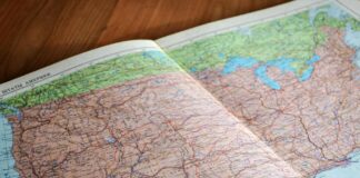 map of the world book laid open on brown wooden surface