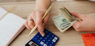 woman calculating money and receipts using a calculator