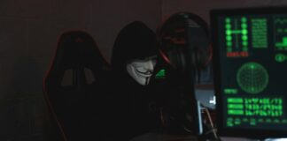 person wearing a mask sitting on chair while using a computer