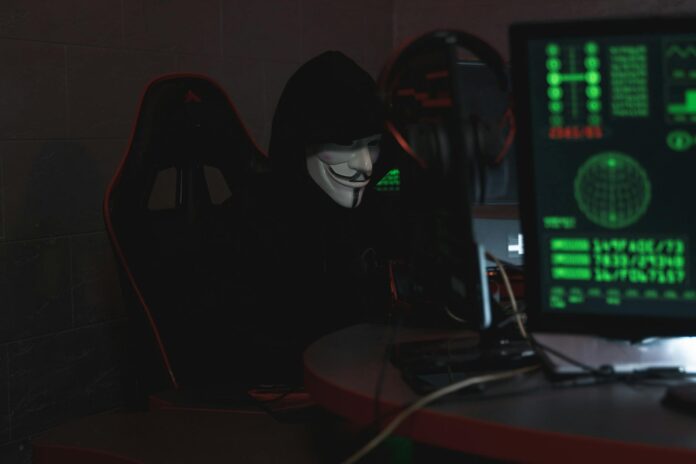 person wearing a mask sitting on chair while using a computer