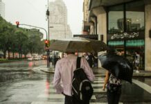 man wearing dress shirt holding an umbrella