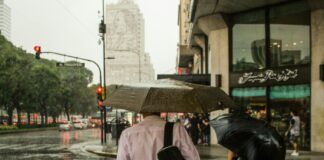 man wearing dress shirt holding an umbrella